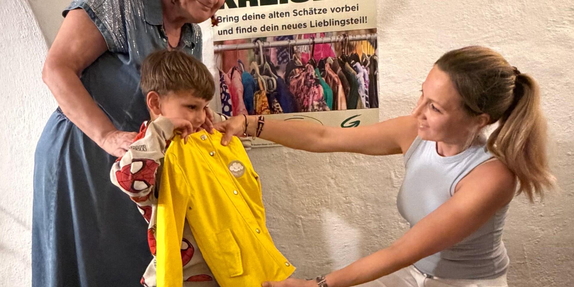 Kinderkleidung: Junge mit gelber Regenjacke und Frau in Salzburg